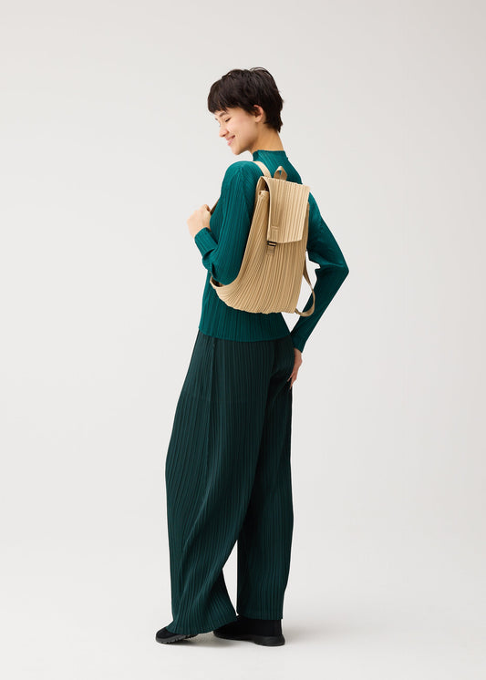 A model wears the PLEATS PLEASE ISSEY MIYAKE PLEATS KNAPSACK pleats-knapsack-backpack-black.